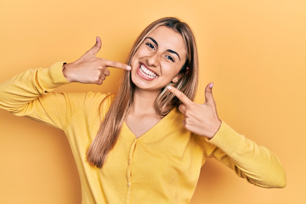 femme montrant son sourire suite au blanchiment dentaire